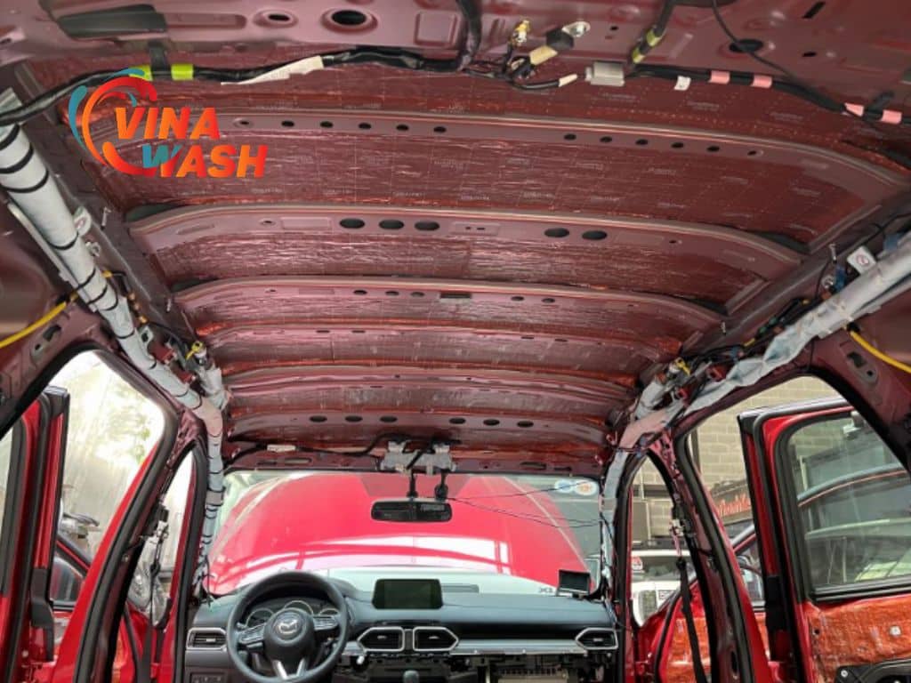 Trần xe Mazda CX-5 màu đỏ được dán cách âm toàn bộ bằng vật liệu màu đồng ánh kim, khung trần xe đã được bó dây gọn gàng