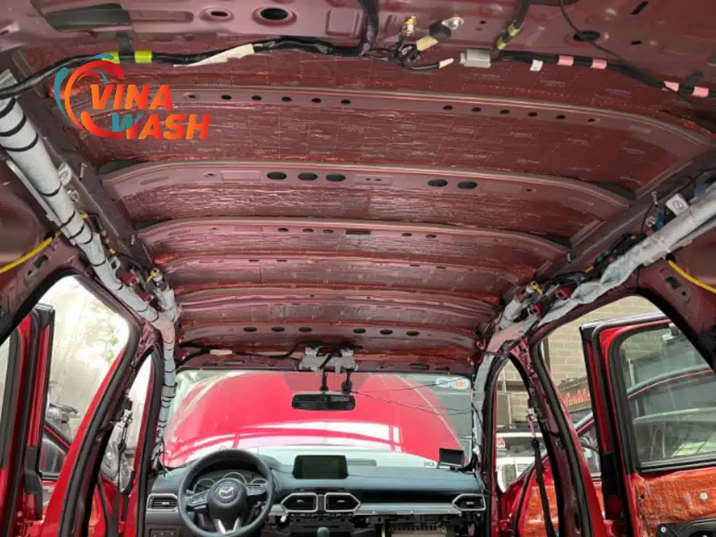 Trần xe Mazda CX-5 màu đỏ được dán cách âm toàn bộ bằng vật liệu màu đồng ánh kim, khung trần xe đã được bó dây gọn gàng