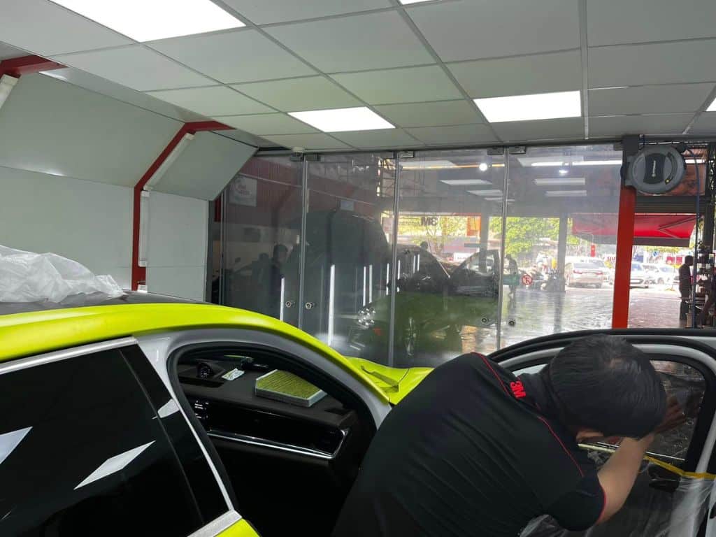 Kỹ thuật viên VinaWash đang thi công dán phim cách nhiệt 3M Crystalline cho xe Porsche