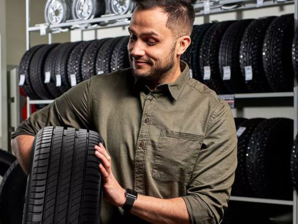Người đàn ông kiểm tra lốp xe Goodyear trong cửa hàng