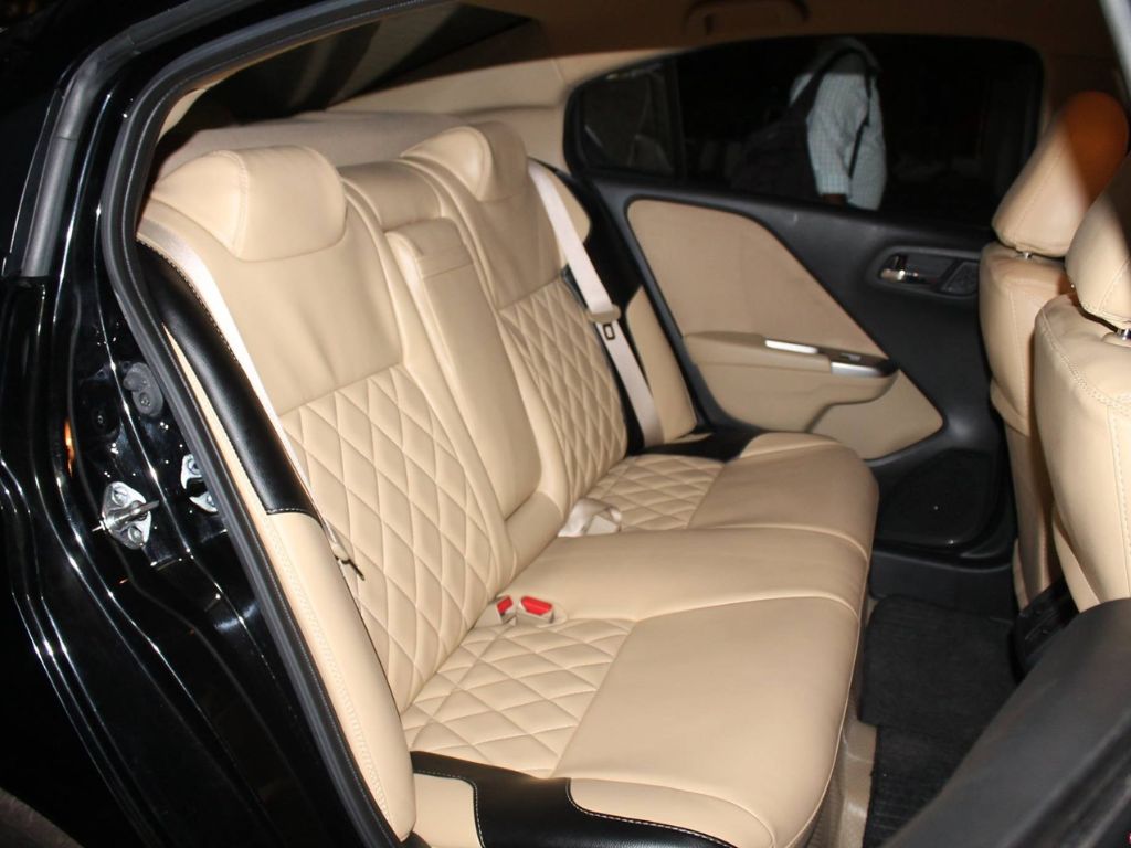 Hàng ghế sau ô tô được bọc da màu be sang trọng, kết hợp họa tiết quả trám tinh tế, tăng tính thẩm mỹ nội thất.