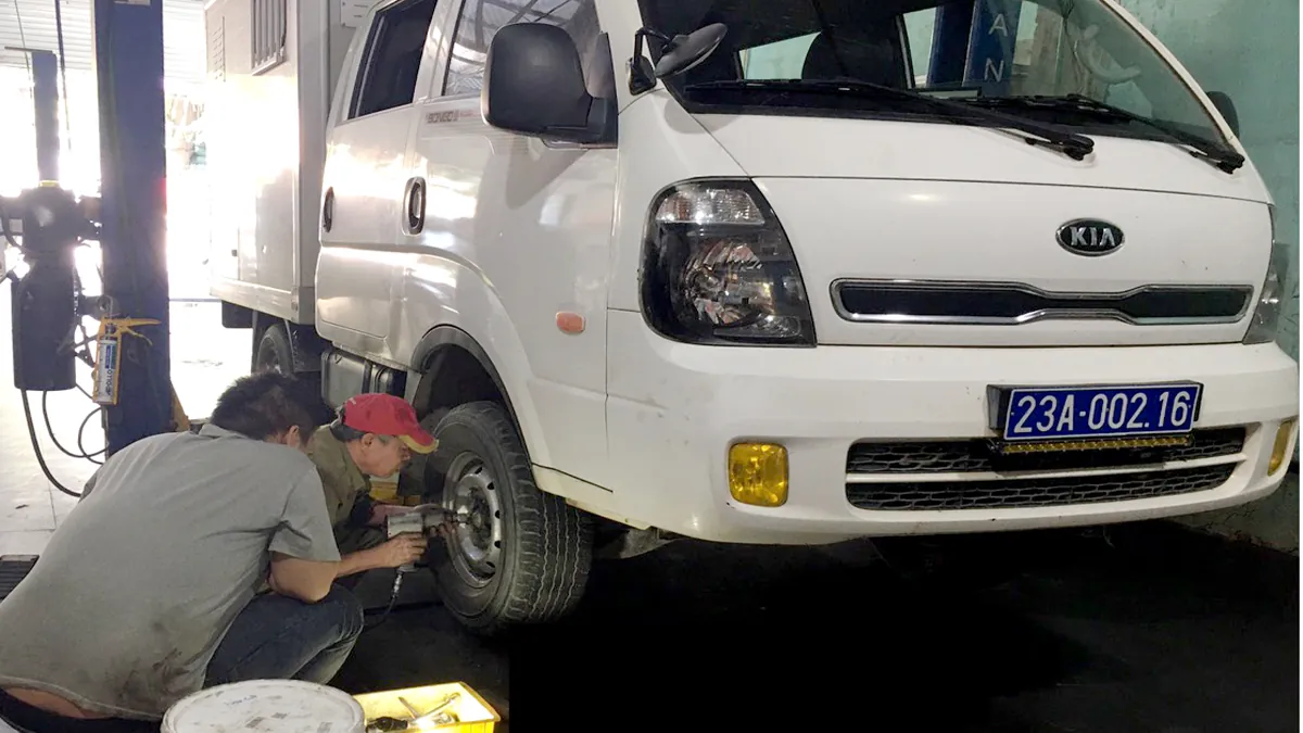 Thợ garage tiến hành thay và cân bằng động lốp xe tải