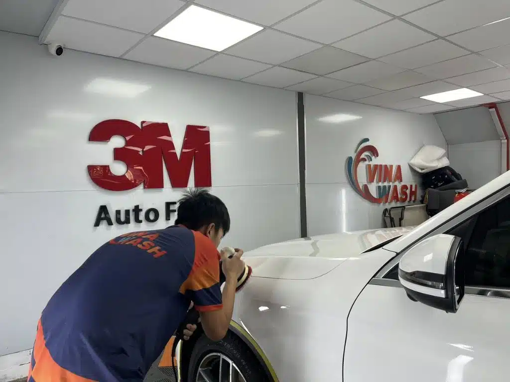 Kỹ thuật viên VinaWash đánh bóng bề mặt xe với sản phẩm 3M, nâng cao chất lượng chăm sóc ô tô.