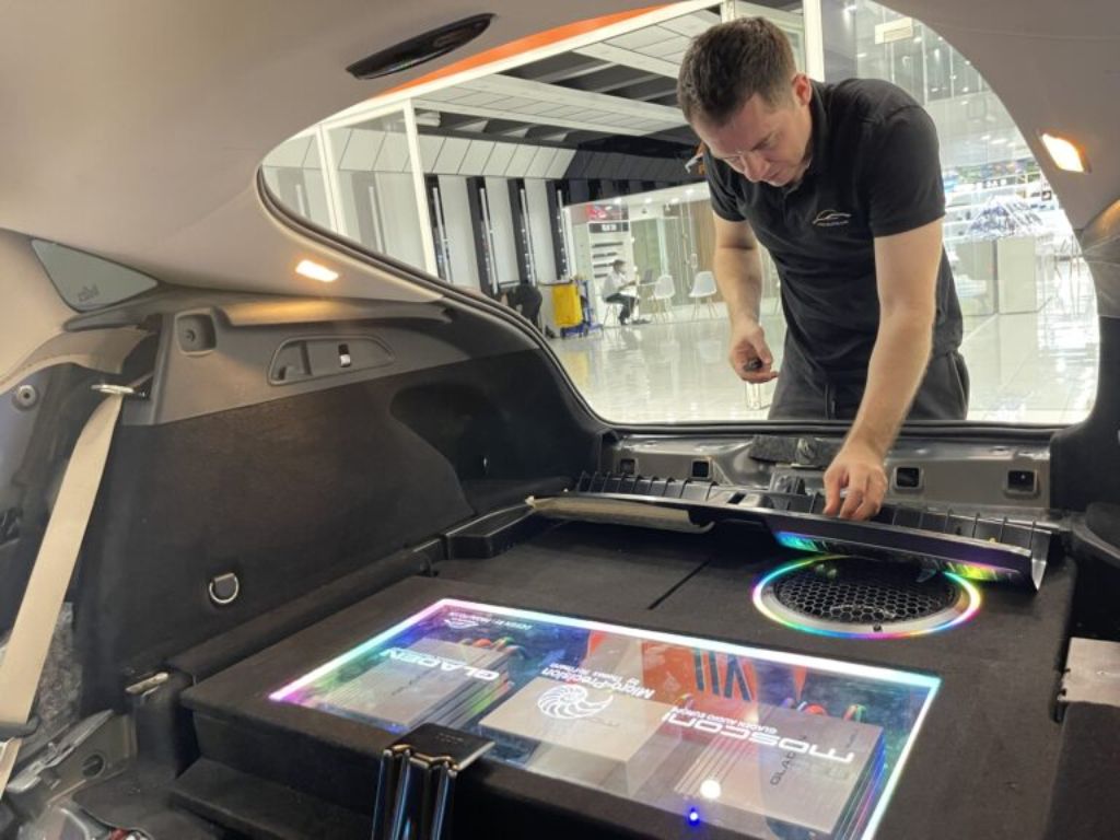 Kỹ thuật viên lắp đặt loa sub ô tô gầm ghế kết hợp amply Mosconi, tối ưu không gian và chất lượng âm thanh.