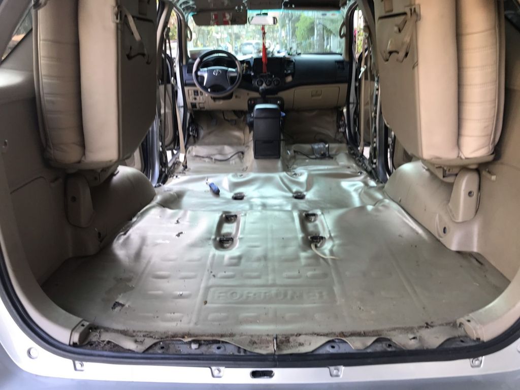 Khoang nội thất ô tô được tháo ghế để chuẩn bị dán lót sàn Simili, làm sạch toàn bộ sàn xe.