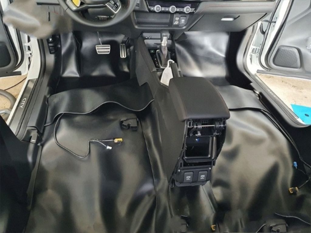 Thi công lót sàn Simili cho ô tô màu đen phủ toàn bộ sàn trước, tăng khả năng chống nước và giảm tiếng ồn.