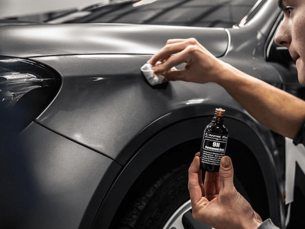 Kỹ thuật viên phủ nano và phủ ceramic lên bề mặt sơn ô tô màu xám bằng dung dịch bảo vệ 9H