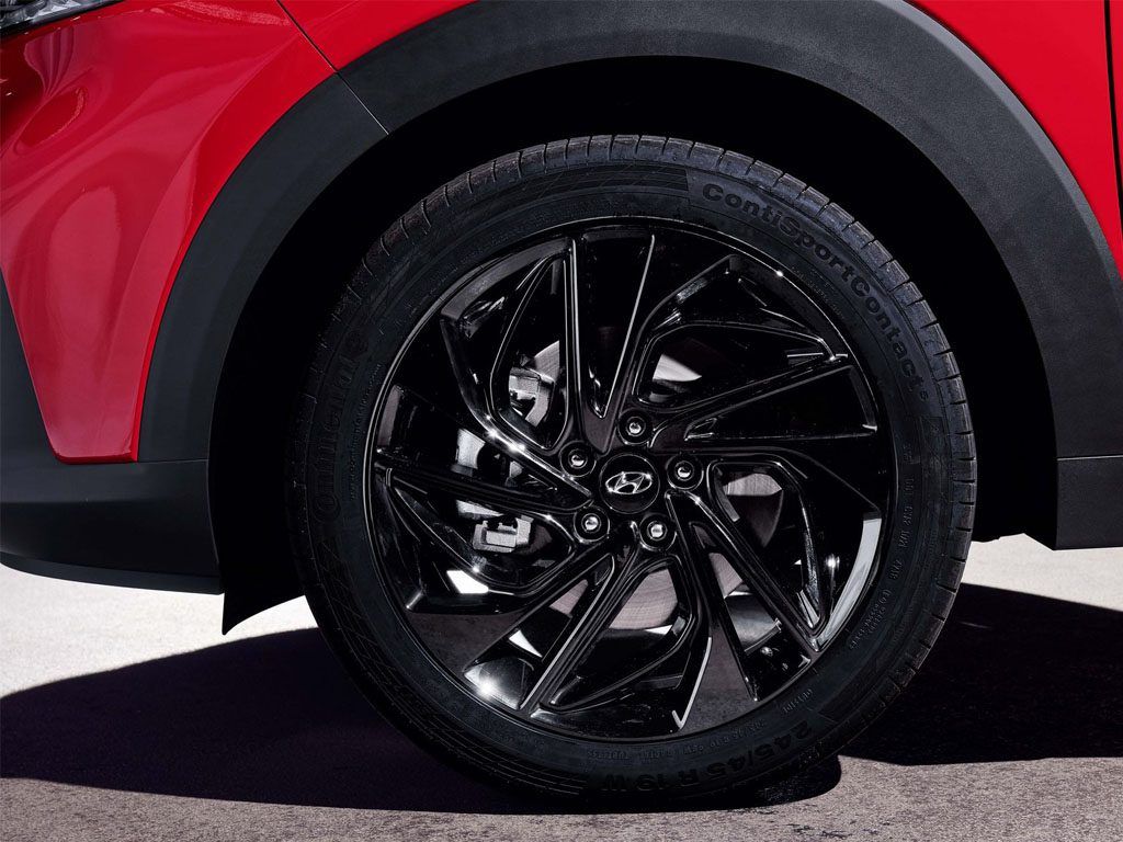 Sơn mâm xe ô tô màu đen bóng nổi bật trên nền xe Hyundai đỏ sang trọng.