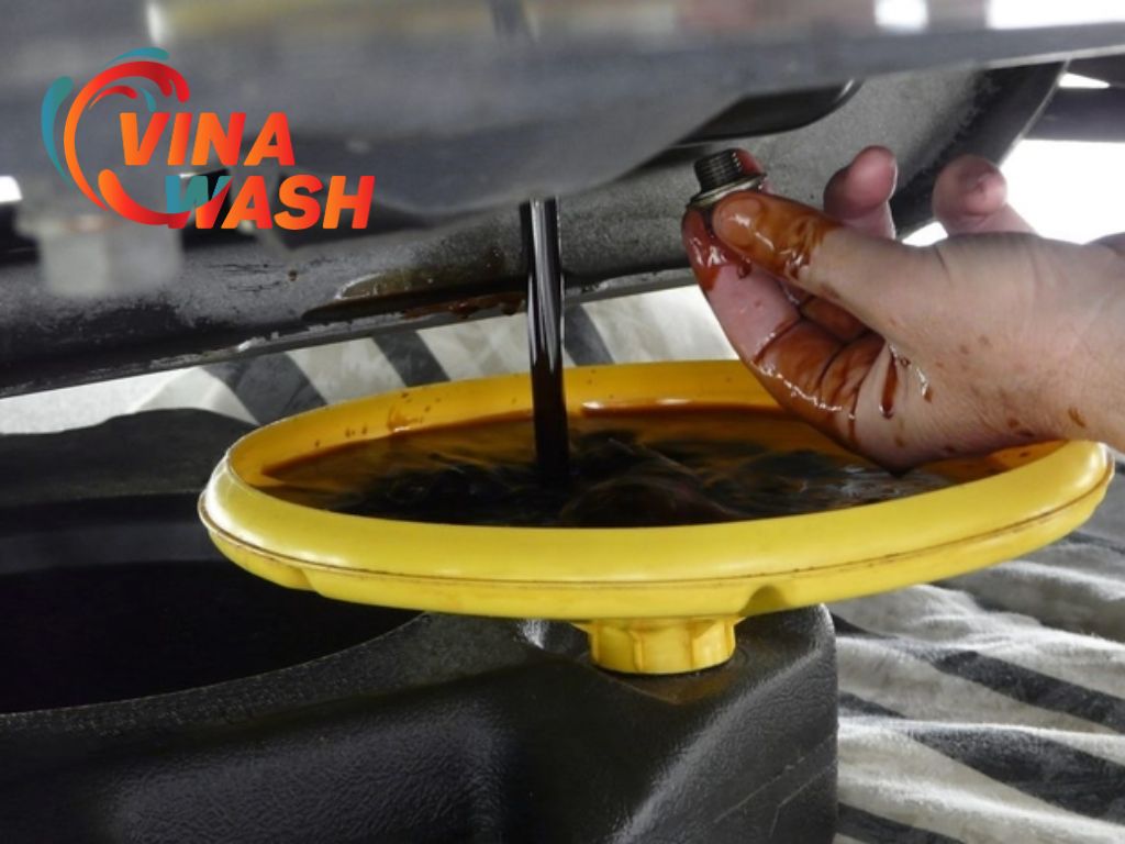 Thợ thay dầu ô tô, dầu được xả ra khỏi động cơ và chuẩn bị cho quá trình thay mới.