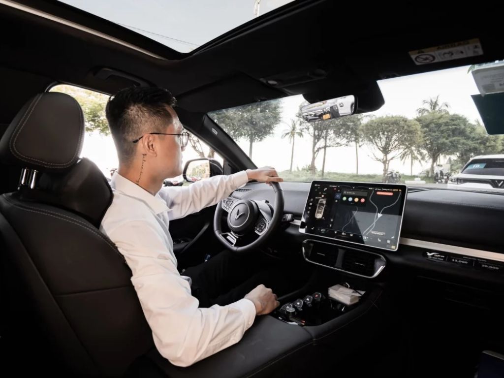 Người đàn ông lái xe điện VinFast bên trong khoang lái hiện đại, thuê xe điện VinFast tự lái tiện lợi.