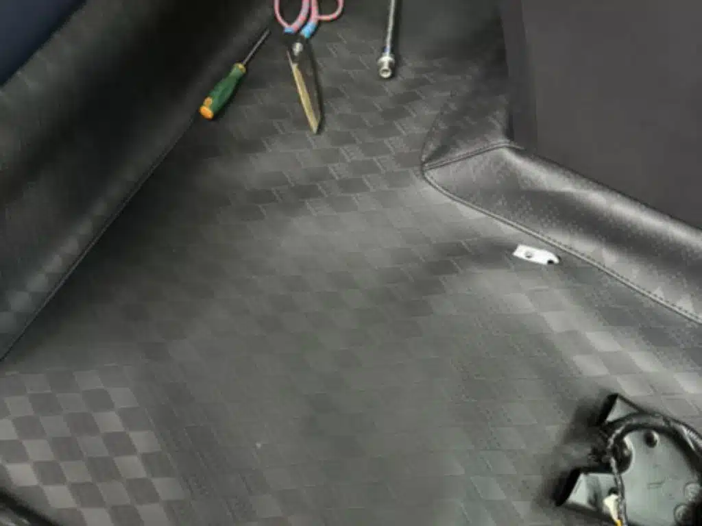 Trải sàn da ô tô loại trơn màu đen chống nước, đang thi công lắp đặt thực tế.