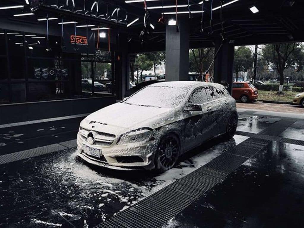Xe Mercedes đang được rửa tại trung tâm chăm sóc xe hơi cao cấp, sử dụng công nghệ tạo bọt tuyết hiện đại.
