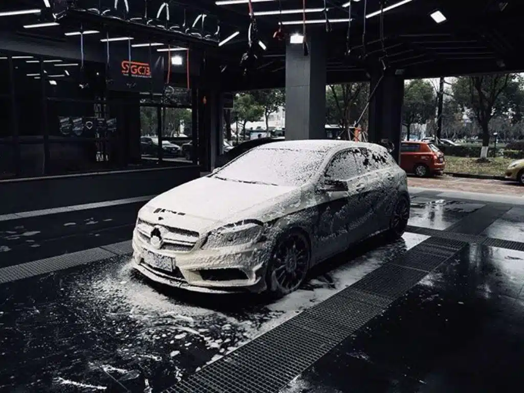 Xe Mercedes đang được rửa tại trung tâm chăm sóc xe hơi cao cấp, sử dụng công nghệ tạo bọt tuyết hiện đại.