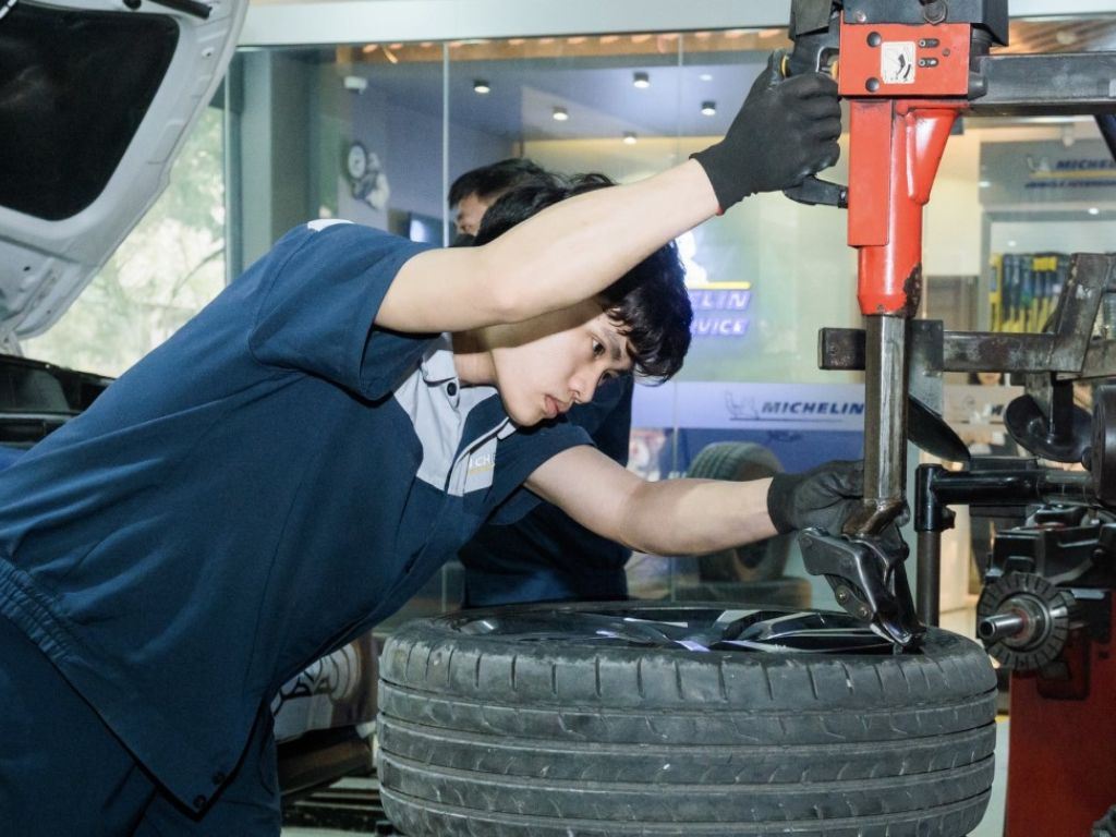 Kỹ thuật viên dùng máy tháo lốp thực hiện vá lốp ô tô tại nhà cho khách hàng.