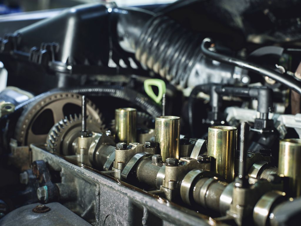 Cận cảnh động cơ ô tô đang được mở nắp để vệ sinh buồng đốt, làm sạch muội than bám trên xupap và trục cam.