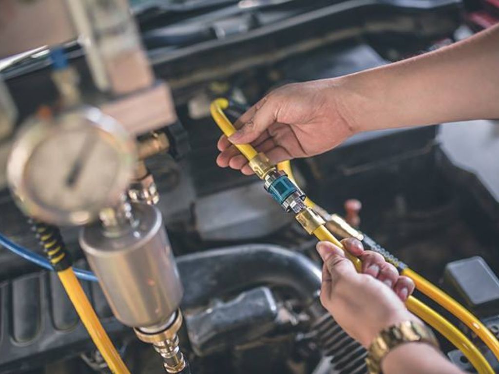 Thực hiện quy trình vệ sinh buồng đốt ô tô bằng thiết bị chuyên dụng, kết nối ống dẫn dung dịch làm sạch hệ thống nạp.