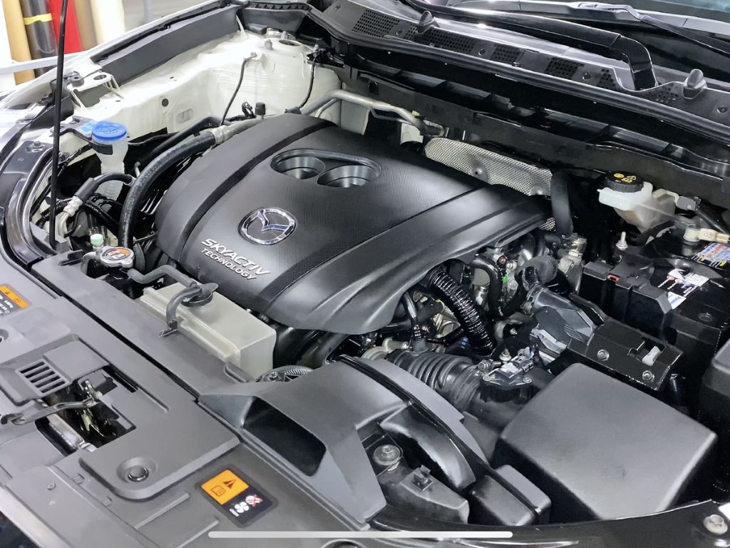 Khoang động cơ Mazda Skyactiv sau khi hoàn tất vệ sinh buồng đốt ô tô, sạch sẽ và vận hành mượt mà hơn.
