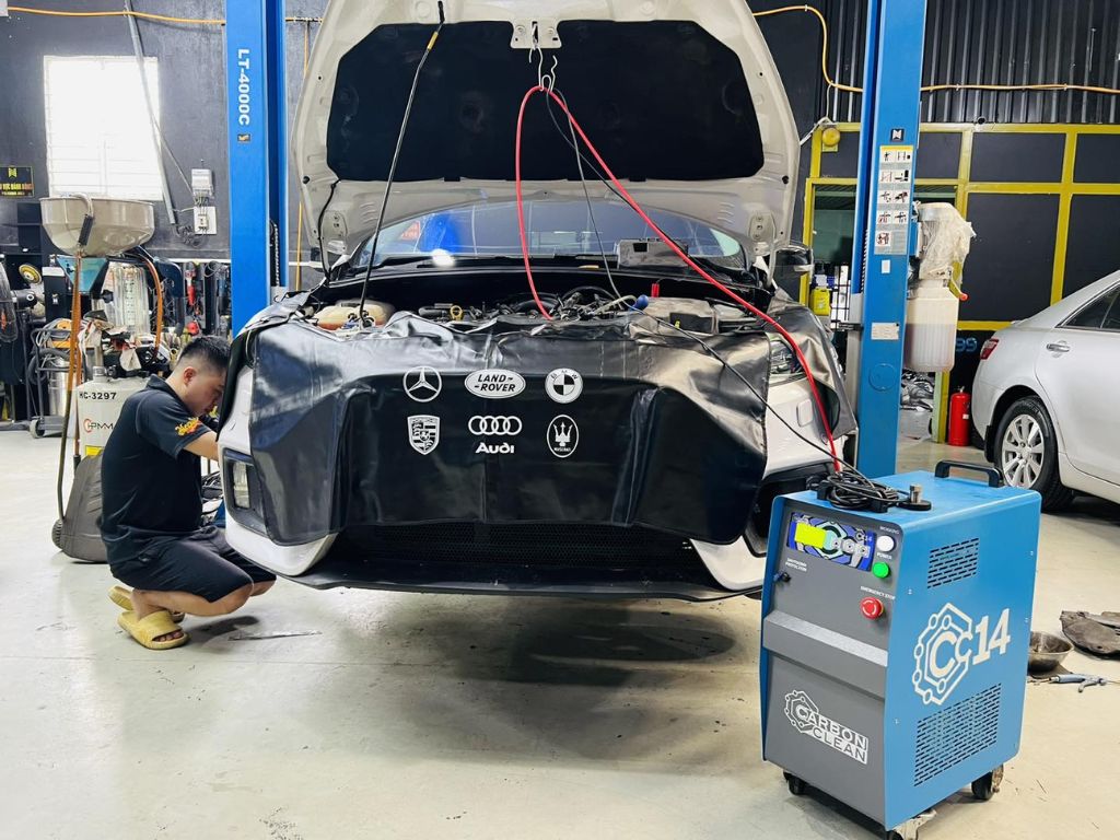 Thợ kỹ thuật đang thực hiện vệ sinh buồng đốt ô tô bằng máy Hydro hiện đại, giúp làm sạch hệ thống nạp và kim phun.