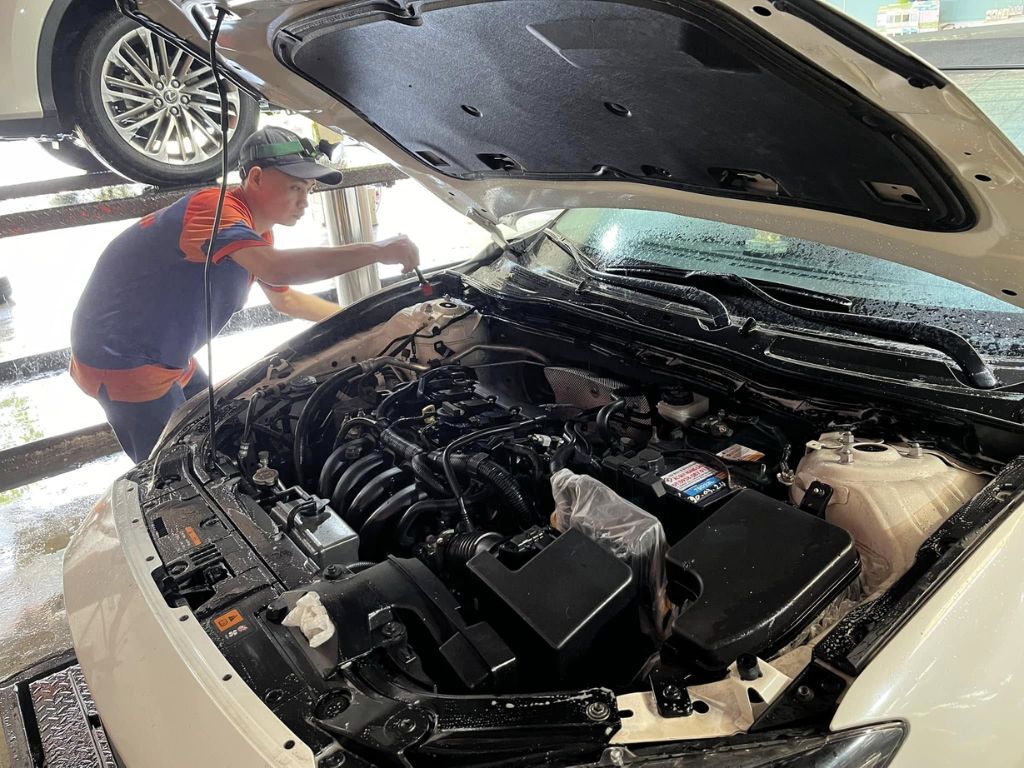 Thợ đang vệ sinh khoang máy ô tô 