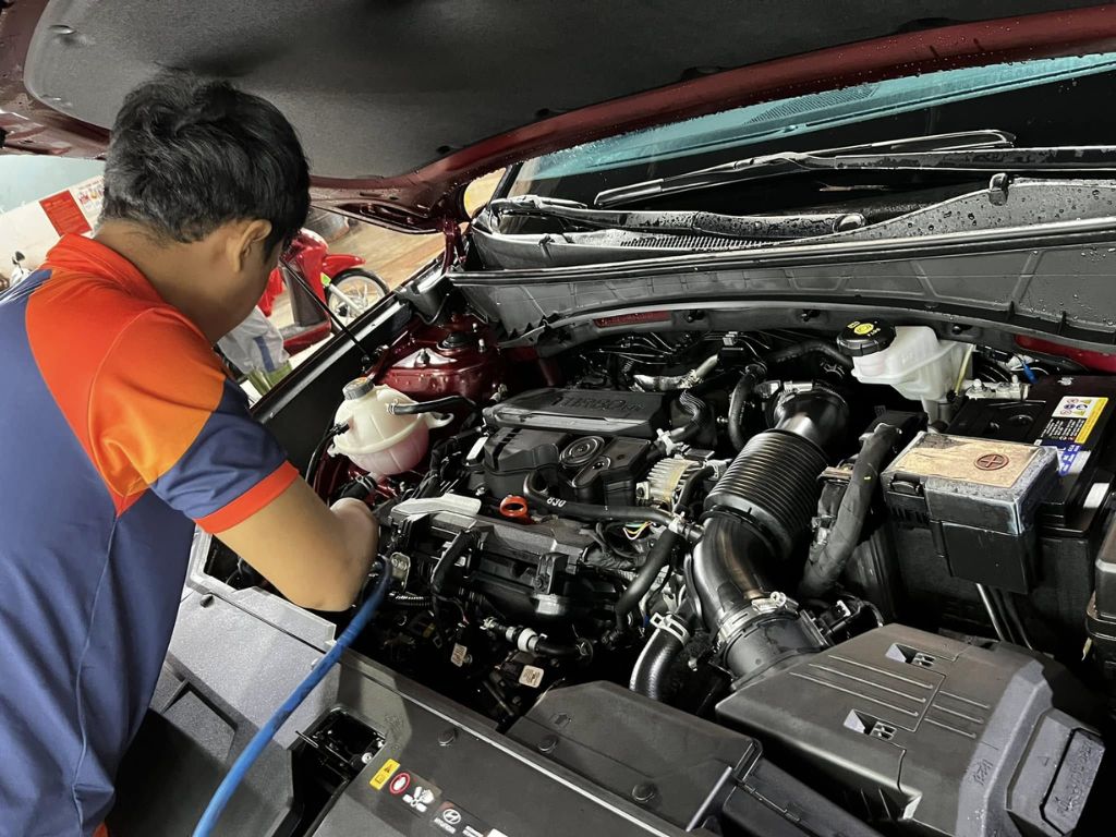 Kỹ thuật viên VinaWash đang vệ sinh khoang máy ô tô TPHCM 