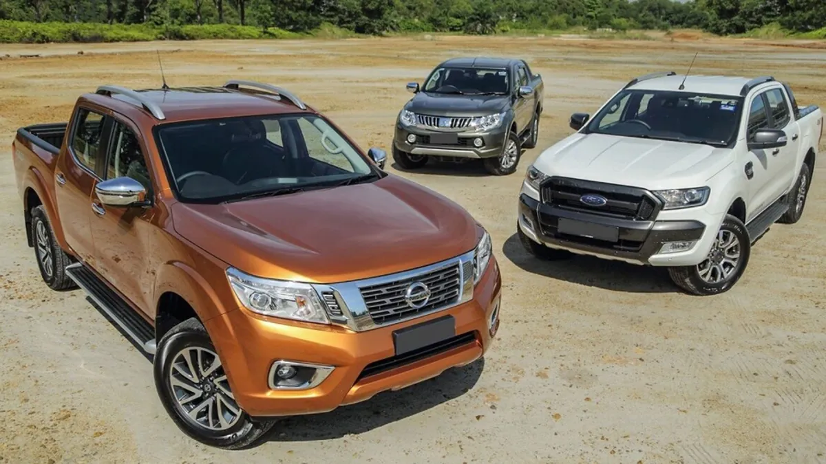 Xe bán tải Nissan Navara, Ford Ranger và Mitsubishi Triton đậu trên bãi đất trống