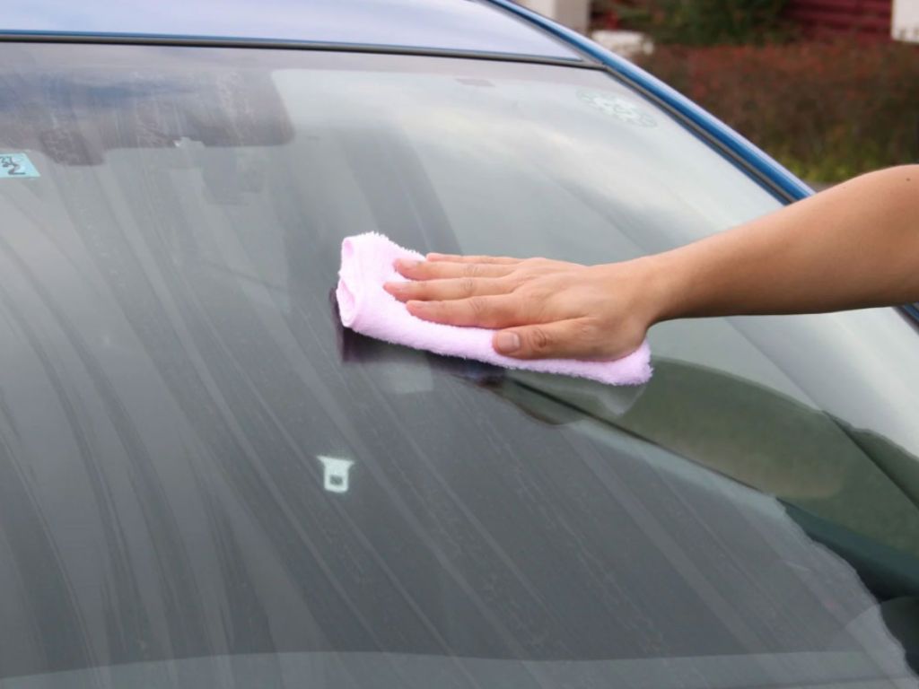 Lau sạch bề mặt kính bằng khăn microfiber – bước đầu tiên trong quy trình cách xử lý kính ô tô tại nhà.