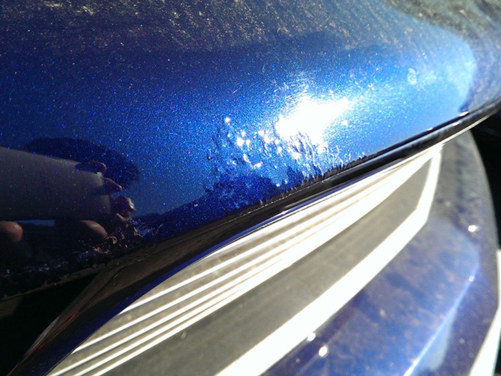 Bề mặt sơn ô tô bị da cam do lỗi sơn không đều, ánh sáng phản chiếu rõ khuyết điểm.