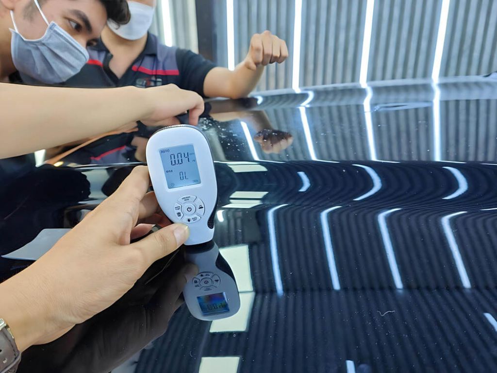 Kỹ thuật viên kiểm tra độ dày sơn ô tô để xác định tình trạng sơn bị da cam.