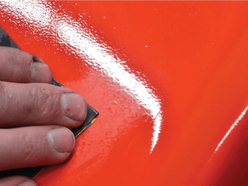 Dùng giấy nhám xử lý bề mặt sơn bị da cam để làm phẳng và mịn lớp sơn ô tô.