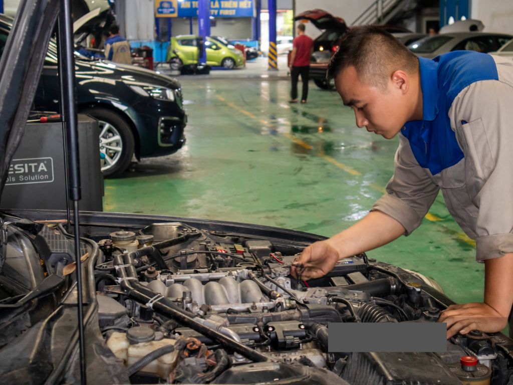 Kỹ thuật viên kiểm tra động cơ trong quy trình xử lý xe ô tô bị ngập nước