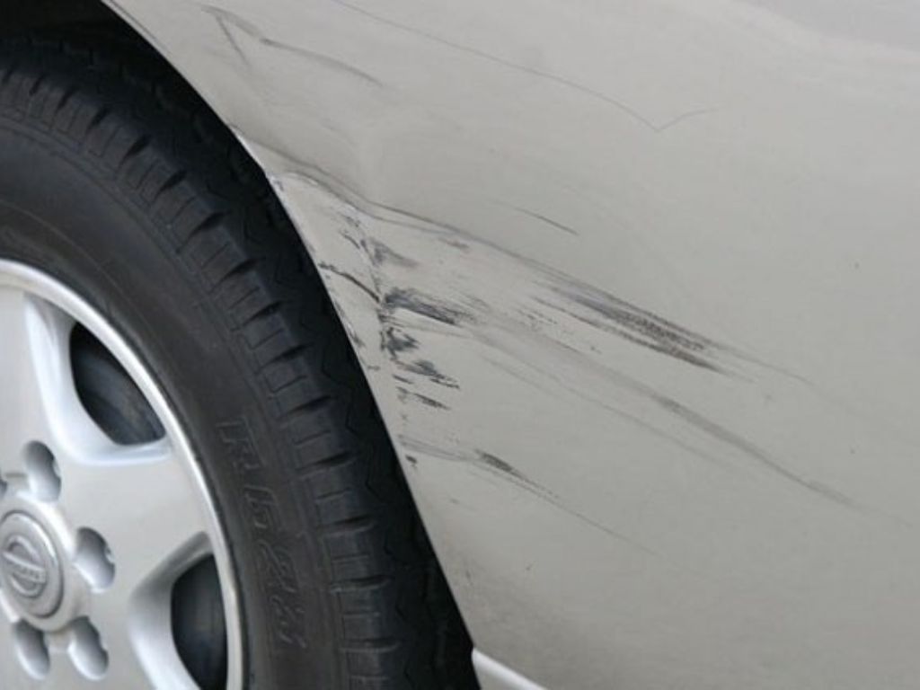 Xe ô tô bị trầy xước nặng phần hông do va quẹt, cần xử lý sơn và đánh bóng lại bề mặt thân xe.