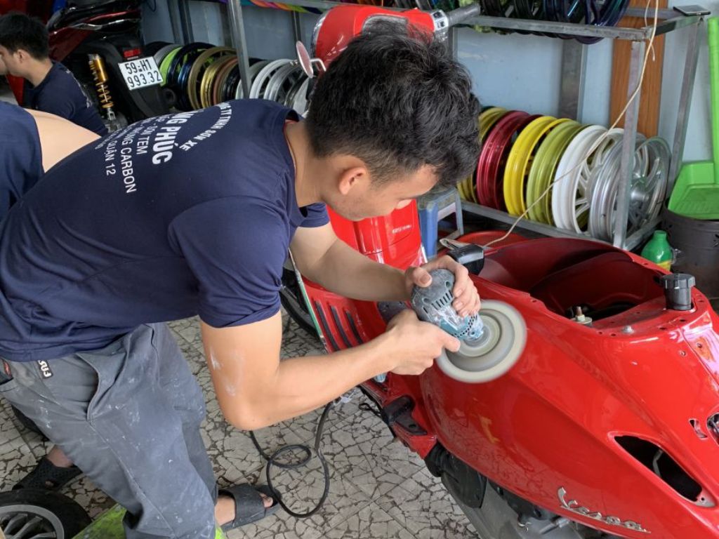 Kỹ thuật viên đánh bóng và xử lý bề mặt trước khi phủ ceramic xe máy.